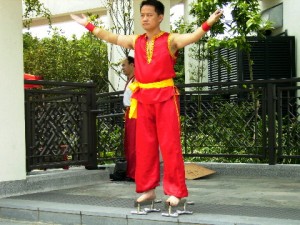 A performer standing on sharp knives with his bare feet