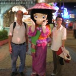 Writer and his wife posing with the pretty cartoon character at Carnival Village