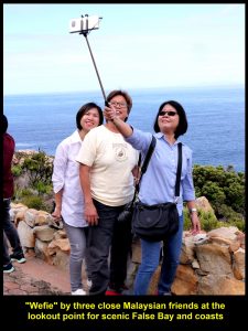 Three close Malaysian friends doing "wefie" at lookout point fpr False Bay and coasts