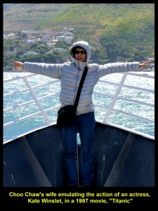 My wife, seemingly, on a ship, "Titanic", emulating the action of Kate Winslet