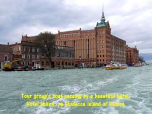 Tour group's boat passing by a beautiful building, Hotel Hilton, on Giudecca Island of Venice