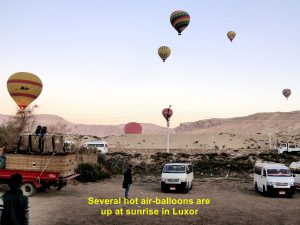 Several hot air-balloons are already in the sky at sunrise in Luxor