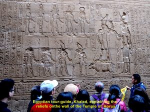 Tour guide, Khaled, explaining the relief on a wall of Temple Horus, Edfu