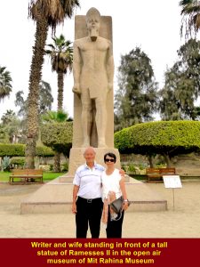 Writer and wife standing in front of a tall statue of Ramesses II in the open museum of Mit Rahina Museum